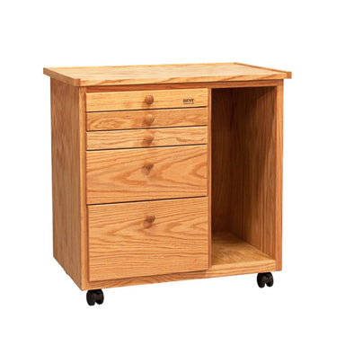 The BEST Studio Taboret 5 Drawer with Cubby by BEST is a compact wooden taboret with a light oak finish, mounted on plastic casters for easy mobility. It features four small drawers and one larger drawer on the left side, with open storage space on the right. The top surface is flat, making it suitable for additional storage or display. Comes fully assembled.