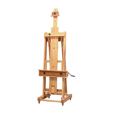 A wooden artist's easel with single-masted oak uprights, adjustable height, and a built-in tray for supplies. The BEST Abiquiu Easel w/ Optional Tray by BEST is designed for holding large canvases and is equipped with wheels for easy mobility.