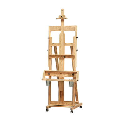 The BEST Classic Santa Fe I Easel by BEST is a wooden single-masted artist's easel on wheels, featuring adjustable height and multiple shelves for storage. The sturdy frame boasts a natural wood finish and metal containers attached to the bottom shelf. A melamine paint mixing surface complements the setup, making it suitable for holding large canvases.